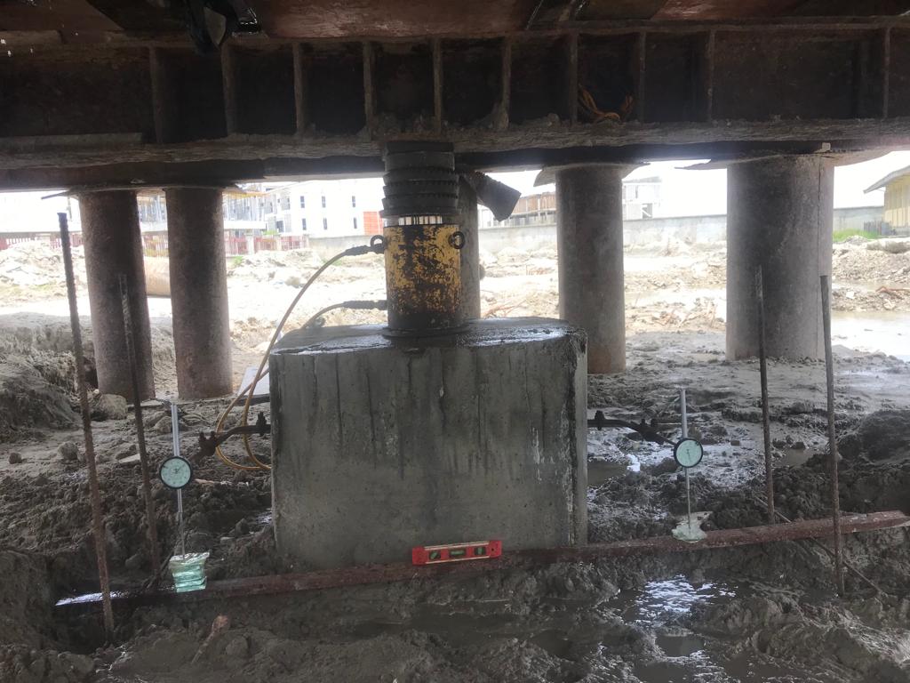 Hydraulic jack and dial gauges recording settlement during a static pile load test